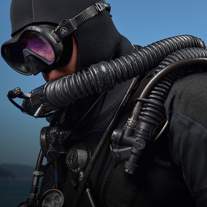 Diver in mask and hood with a HYDPRO power inflator and corrugated hose on the harness